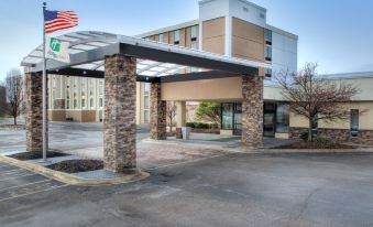 a large building with a stone entrance and a parking lot in front of it at Best Western Plus Strongsville Cleveland