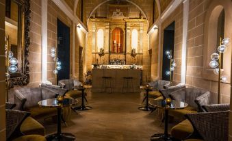 a dimly lit bar with several chairs and tables , as well as a piano in the background at Hotel Creu de Tau Art&Spa-Adults Only