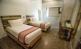 a modern hotel room with two beds , white bedding , and wooden frames , along with a study area at The Bricks Hotel