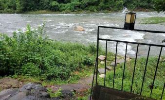 From the doorway, there is a view of a water and dirt path surrounded by trees on both sides at Gapyeong Dasom Pension