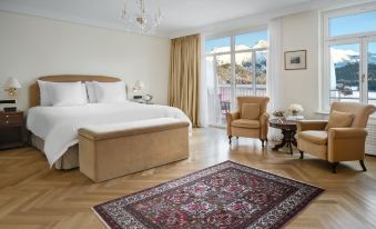 a spacious bedroom with a large bed , two chairs , and a rug on the floor at Badrutt's Palace Hotel