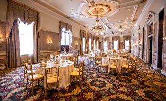 a large banquet hall with multiple round tables and chairs , all set for a formal event at Bourbon Orleans Hotel