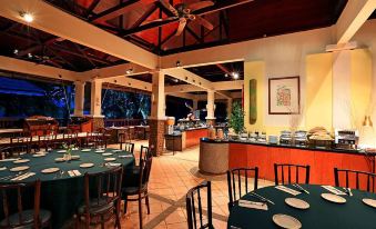 a large dining room with multiple tables and chairs , as well as a buffet table filled with food at Mutiara Taman Negara