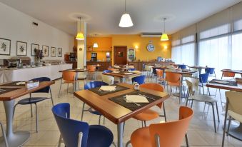 a large dining room with several tables and chairs arranged for a group of people to enjoy a meal together at Best Western Titian Inn Hotel Venice Airport