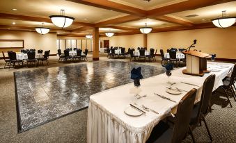 a large , well - lit banquet hall with tables set for dining , complete with cutlery and napkins at Best Western Plus Barclay Hotel