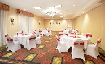 a large dining room with multiple tables and chairs arranged for a formal event , possibly a wedding reception at Hilton Garden Inn Casper