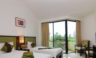 a hotel room with two beds , a window offering a view of the outdoors , and a painting on the wall at Kuiburi Hotel & Resort