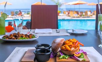 a dining table with a plate of food and a view of the ocean in the background at Venezuela Marriott Hotel Playa Grande