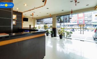 a modern hotel lobby with a large window and potted plants , creating a welcoming atmosphere at Alpha Inn