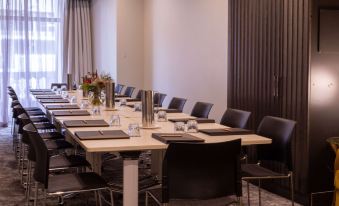 a conference room set up for a meeting , with several chairs arranged in a semicircle around a long table at DoubleTree by Hilton Wellington