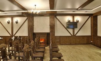 a large room with wooden furniture , including chairs and a table , as well as a fireplace at Voyage