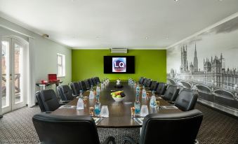 a large conference room with a long wooden table and multiple chairs arranged around it at Lion Quays Resort