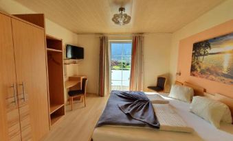 a spacious bedroom with a king - sized bed , a television , and a window overlooking a pool at Gasthof Zur Post