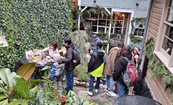 a group of people gathered in a courtyard , surrounded by greenery and enjoying a meal together at Town's Inn