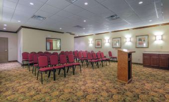 a conference room with red chairs arranged in rows and a podium at the front at Country Inn & Suites by Radisson, Emporia, VA