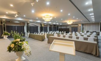 a conference room set up for a meeting , with rows of chairs arranged in a semicircle at Chaipat Hotel