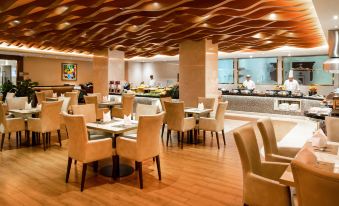 The restaurant features tables and chairs in the center, as well as additional seating areas at Holiday Inn Macau