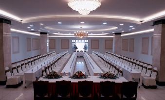 a large banquet hall with long tables and chairs arranged for a formal event , possibly a wedding reception at Tre Xanh Hotel