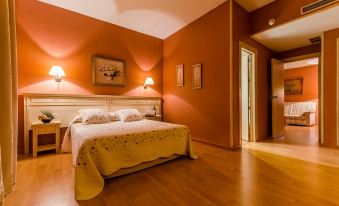 a bedroom with a large bed , orange walls , and a wooden floor , lit by two lamps at Zodiaco