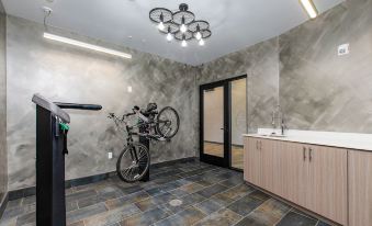 a bicycle is parked on a wall in a room with marble flooring and a wooden cabinet at The Independence Hotel