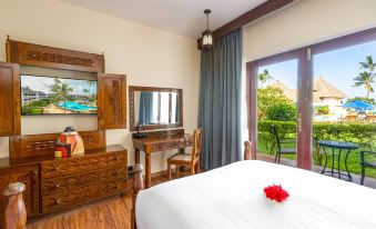 a modern hotel room with wooden floors , white bedding , and a large window offering views of the garden at Nungwi Beach Resort by Turaco