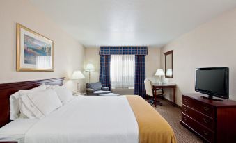a large bed with a gold blanket is in the middle of a hotel room at Holiday Inn Express & Suites Jackson