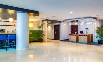 a modern hotel lobby with a reception desk and a potted plant , creating a welcoming atmosphere at Park Inn by Radisson Dammam