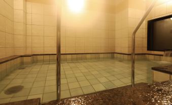 A spacious room with tiled flooring and an adjacent indoor pool at AB Hotel Kisarazu