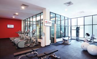 a well - equipped gym with various exercise equipment , such as treadmills , stationary bikes , and weight machines at Hilton Garden Inn Puchong