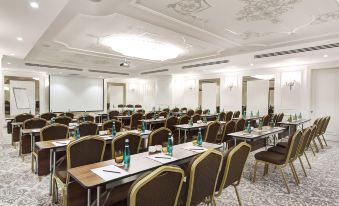 a large conference room with rows of chairs and tables , bottles on each table , and a mirror in the ceiling at DoubleTree by Hilton Gaziantep