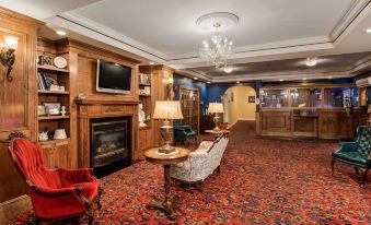 a spacious room with wooden walls , a fireplace , and a television , decorated with chandeliers and red carpet at Best Western White House Inn