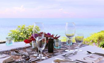 a table is set with wine glasses , silverware , and a view of the ocean in the background at Curacao Marriott Beach Resort