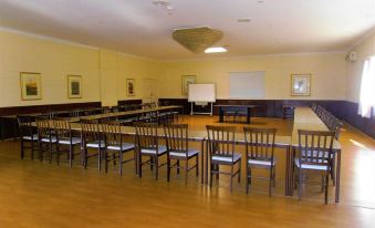 a large conference room with multiple rows of chairs arranged in a semicircle , and a whiteboard on the wall at Picton Valley Motel Australia