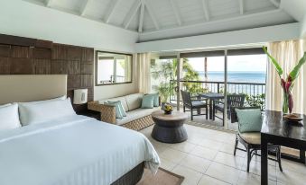 a bedroom with a large bed , couch , and sliding glass doors leading to a balcony at Shangri-La Yanuca Island, Fiji