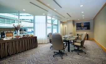 a conference room with a large window , chairs , and tables , as well as a blue carpeted floor at Pan Pacific Vancouver