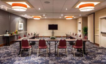 a conference room with multiple round tables and chairs arranged in a semicircle , providing seating for a group of people at DoubleTree Suites by Hilton Minneapolis