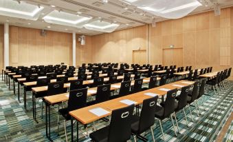 a large conference room with rows of chairs arranged in a semicircle , ready for a meeting at Hilton Helsinki Airport