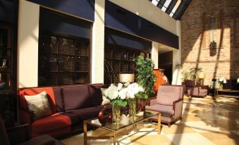 a living room with a brown couch , purple chairs , and a coffee table in the center at DoubleTree by Hilton Hotel Murfreesboro