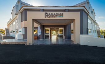"a large building with a sign that says "" paradise plaza "" in front of it" at Paradise Resort