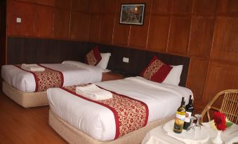 a hotel room with two beds , one on the left and one on the right side of the room at Hotel Srinagar