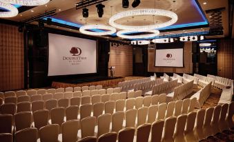 a large conference room with rows of chairs arranged in a semicircle , ready for an event at DoubleTree by Hilton Melaka