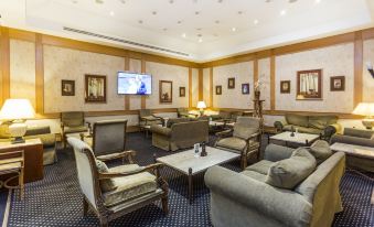 a large room with multiple couches and chairs arranged in a seating area , creating a cozy atmosphere at Riviera Hotel
