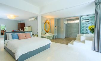 a modern bedroom with a large bed and white walls , featuring a glass door leading to a bathroom at Villa Moreeda