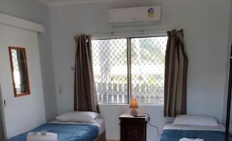 a room with two beds , one on the left side and the other on the right side of the room at Cooktown Motel