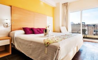 a large bed with white sheets and a wooden headboard is in a room with yellow walls at Hotel Fontana Plaza