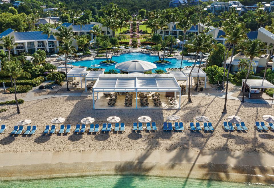 aerial view of a resort with multiple pools , beach chairs , and umbrellas , surrounded by lush greenery at The Westin St. John Resort Villas