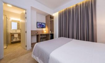 a hotel room with a bed , tv , and desk , along with curtains and a window at Hotel Son Vilar