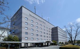 "a large , gray building with multiple antennas on top and a sign that reads "" nippon kogaku hospital .""." at Hiroshima Airport Hotel