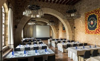 a large dining room with multiple tables and chairs arranged for a group of people to enjoy a meal together at Parador de Siguenza