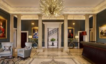 a grand foyer with a staircase leading to the second floor , surrounded by marble floors and walls at The Langley, a Luxury Collection Hotel, Buckinghamshire